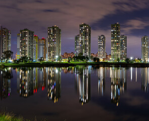 A modern night city with a reflection over the lake