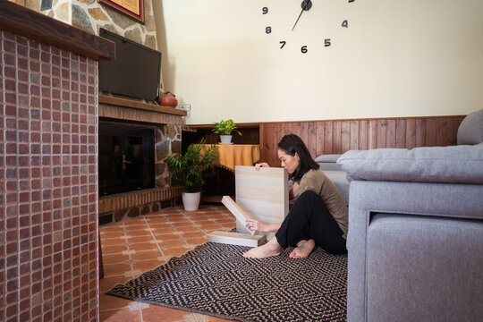 Asian woman assembling table in living room