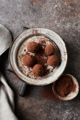 Chocolate candies. Delicious dessert on a brown background. Chocolate truffles in cocoa. Macro photography of sweets. Close-up of the candy. Space for text