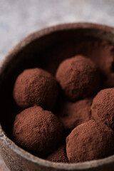 Chocolate candies. Delicious dessert on a brown background. Chocolate truffles in cocoa. Macro photography of sweets. Close-up of the candy. Space for text