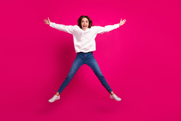 Fototapeta na wymiar Full length photo of young cheerful girl happy positive smile have fun jump star isolated over pink color background