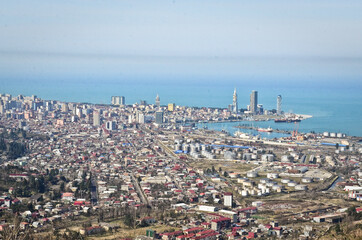 BATUMI, GEORGIA: Aerial scenic view of Batumi city center with skyscrapers and old houses with mountains in the background 