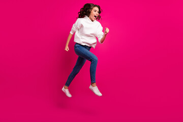 Full body profile side photo of young excited girl happy positive smile jump go walk run hurry sale isolated over pink color background