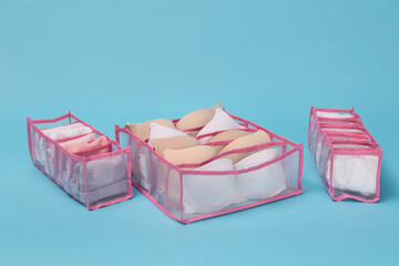 Transparent organizers with underwear on light blue background