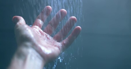 Water pouring from shower on hand