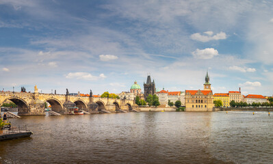 waterfront view across the river Vltava to the Charles Bridge and Old Town Bridge Tower, Prague,...