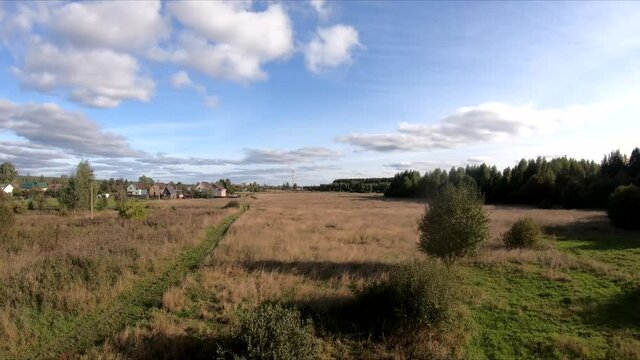flying on an fpv drone behind a horse, a girl on a horse, in a green field, against the background of a forest, bushes, trees, blue sky, white clouds