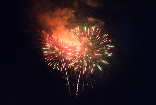 People watching beautiful bright fireworks outdoors at night