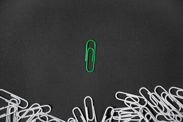 green paper clip unique idea concept. isolated on black background. Space for your text