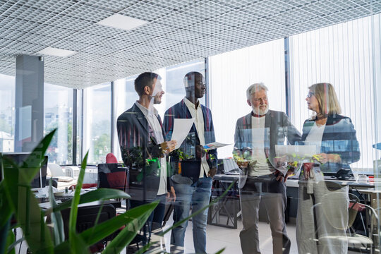 Four diverse business workgroup team with african man leader discuss paperwork financial report statistical data, Brainstorm, briefing activity concept - Powered by Adobe