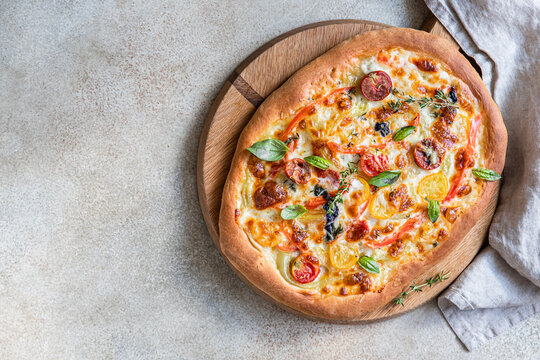 Pinsa with vegetables and cheese, concrete background. Traditional rome pizza. Top view.