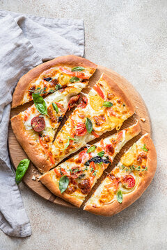 Pinsa with vegetables and cheese, concrete background. Traditional rome pizza. Top view.