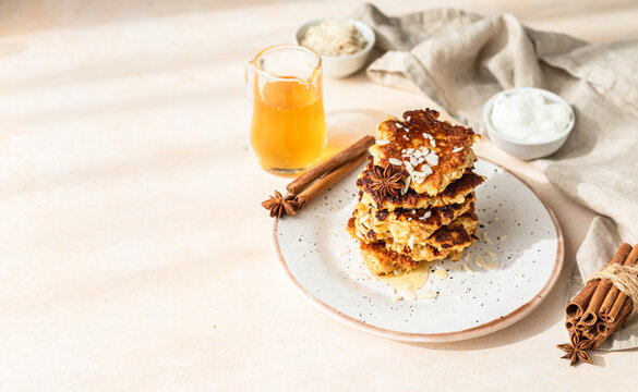 Stack of delicious apple pancakes or fritters with honey, spices and almond. Sunny morning. Autumn breakfast. Copy space.