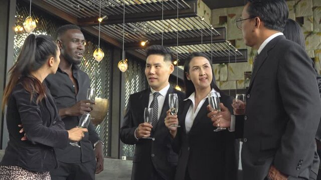 Group of diversity business people holding champagne glasses and discussing at the corporate meeting. New Year event or company party