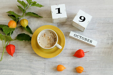 Calendar for October 19 : the name of the month in English, cubes with the number 19, a yellow cup...