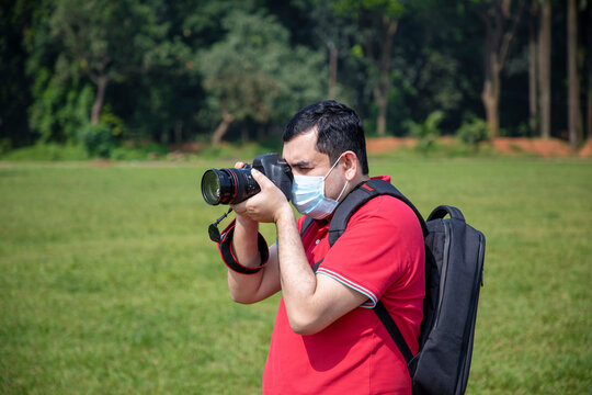 Photographer capturing photos during Coronavirus disease (COVID-2019) pandemic wearing face mask