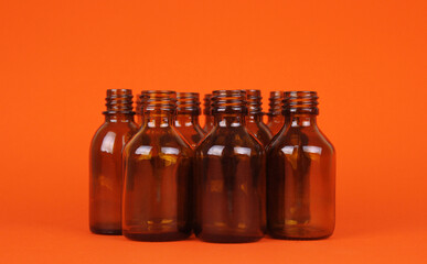 Empty brown glass bottles on orange background