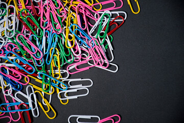 Bunch of colorful paper clips isolated on black background