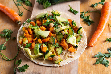 Vegan burrito with chickpeas, zucchini, carrots and avocado - obrazy, fototapety, plakaty
