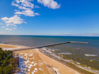 Aerial view of Palanga pedestrians bridge to the sea and coastline with sandy beach in winter