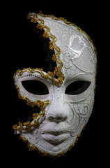 Mardi Gras female half mask in white in gold isolated against black background.