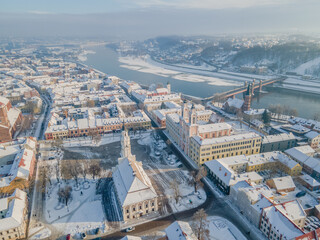 Aerial panorama of Kaunas city (Lithuania) old town, located in confluence of two river. City hall in the main square, cathedral, other churches and snowy roofs.