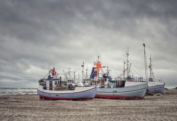 Fototapeta premium Fischerboote liegen am Nordseestrand bei Ebbe