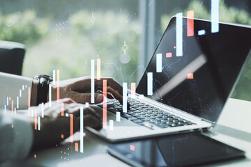 Double exposure of abstract creative financial chart with hand typing on computer keyboard on background, research and strategy concept