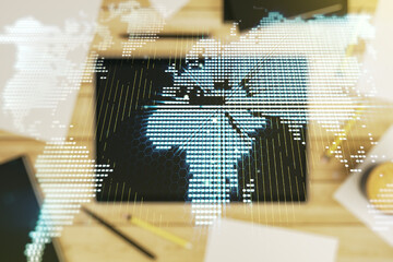 Abstract creative digital world map and modern digital tablet on desktop on background, top view, globalization concept. Multiexposure