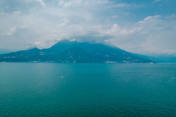 Photo of foggy mountains in Como lake on a cloudy day in Lombardy, Italy