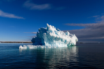 Beautiful iceberg in Arctic sea at sunny day. Big piece of ice in sea close up.