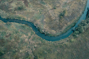 natural background, river among the autumn grass in the field, view from the top.