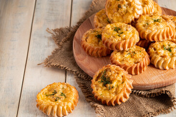 Fresh muffins with vegetables and cheese on wooden board. Delicious homemade cakes for healthy diet. Recipe for autumn seasonal dish.