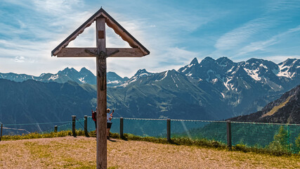 Beautiful alpine summer view with a religious cross at the famous Fellhorn summit near Oberstdorf, Bavaria, Germany