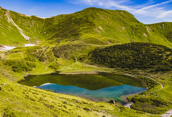Beautiful alpine summer view with reflections in a lake at the famous Fellhorn summit near Oberstdorf, Bavaria, Germany