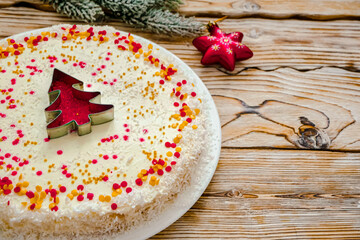 Christmas cake with white cream and a red gold  Christmas tree made of sprinkles. Homemade Christmas cake in red and gold flat lay copy space. Christmas food background top view