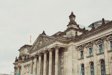 Fototapeta na wymiar Isola dei musei a Berlino + vista sul parlamento con bandiera della Germania. Architettura in stile romano.