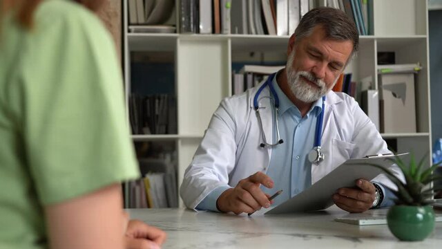 Smiling male professional doctor handshakes female patient agree on surgery, medical service trust concept