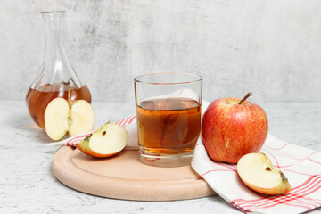 Apple juice on wooden stand with carafe full of juice at the background