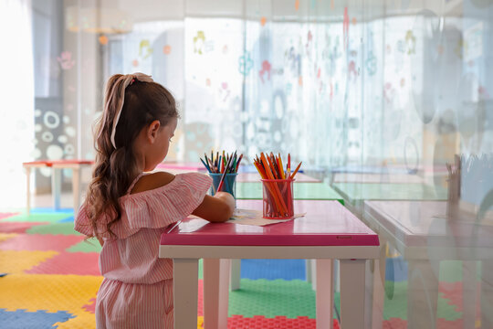 Little girl drawing with color pen in paper on table at playroom, Baby healthy and preschool concept