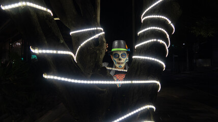 hombre con disfraz de calavera día de muertos halloween con sombrero entre luces led