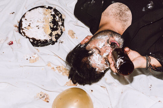 Drunk man drinking beer during birthday party