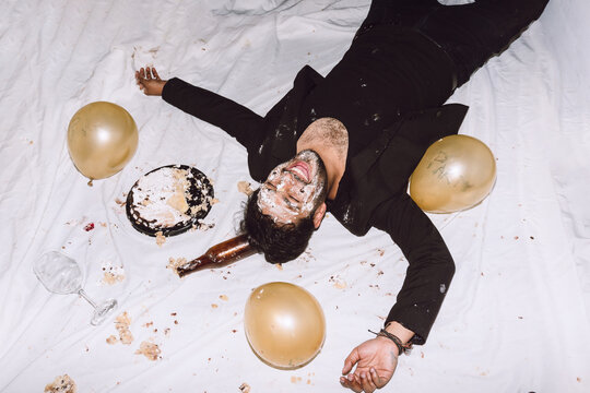 Happy man in smashed cake with eyes closed