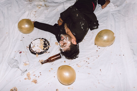 Happy man in smashed cake with eyes closed