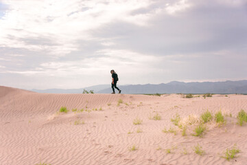 Man walking on desert dunes