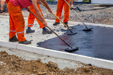 Workers leveling hot asphalt