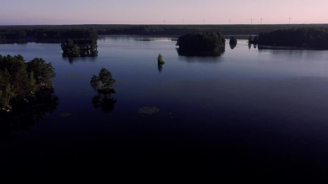 See in Schweden. Idylle im Smaland zur blauen Stunde vor Sonnenaufgang. Drohneflug über den ruhigen See. Der Himmel ist blau rosa magenta.