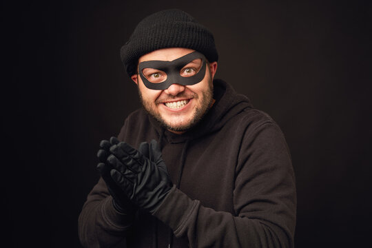 Portrait of funnu thief with mask over dark back