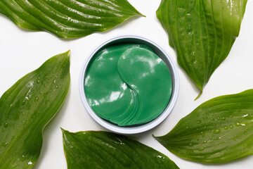 Obraz premium under eye patches. cosmetics collagen hydrogel patch among green leaves. Lifting anti-wrinkle mask under eyes. Skincare concept.