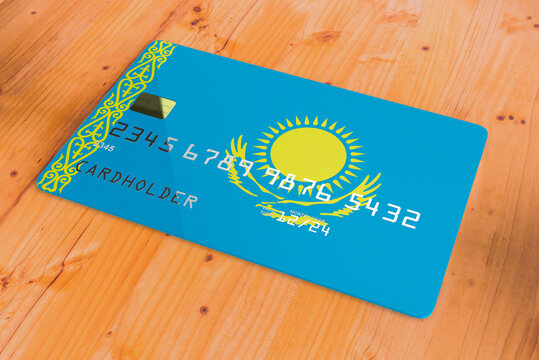 Plastic credit or bank debit card with country flag of Kazakhstan national banking system isolated on wooden table close up concept 3d rendering image